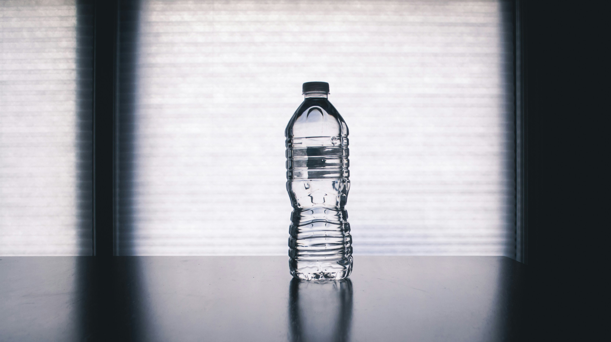 Flasche destilliertes Wasser neben einem Haushaltsgerät